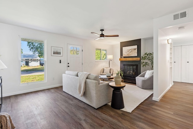 living area with dark wood-type flooring, visible vents, and a wealth of natural light