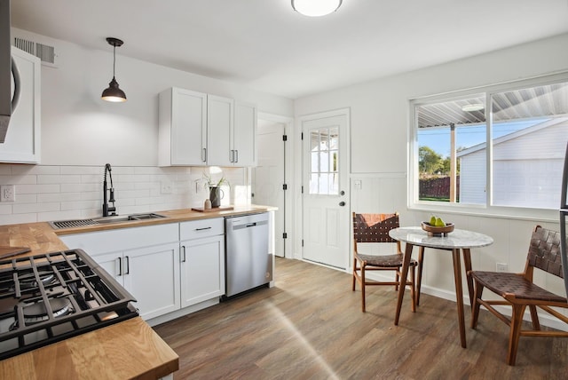 kitchen featuring a sink, wood counters, stainless steel dishwasher, wood finished floors, and white cabinets