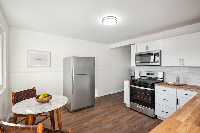 kitchen with white cabinetry, dark wood-style floors, appliances with stainless steel finishes, and wooden counters