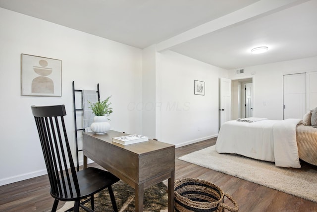 bedroom with dark wood-style floors, visible vents, and baseboards