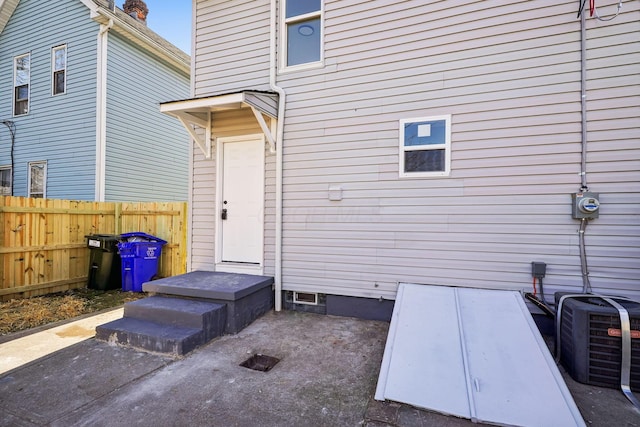 property entrance featuring cooling unit and fence