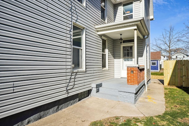 property entrance featuring a porch and fence