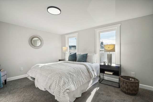 bedroom featuring dark colored carpet and baseboards