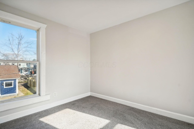 carpeted empty room featuring baseboards