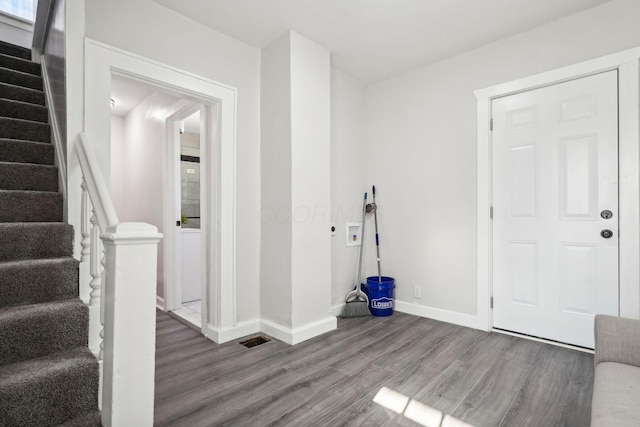 entryway featuring stairs, wood finished floors, and baseboards