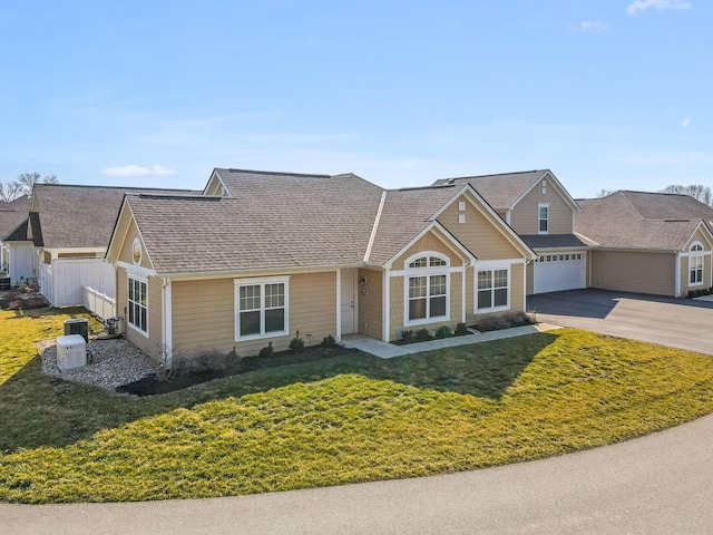 view of front facade featuring a front lawn, cooling unit, a garage, and driveway