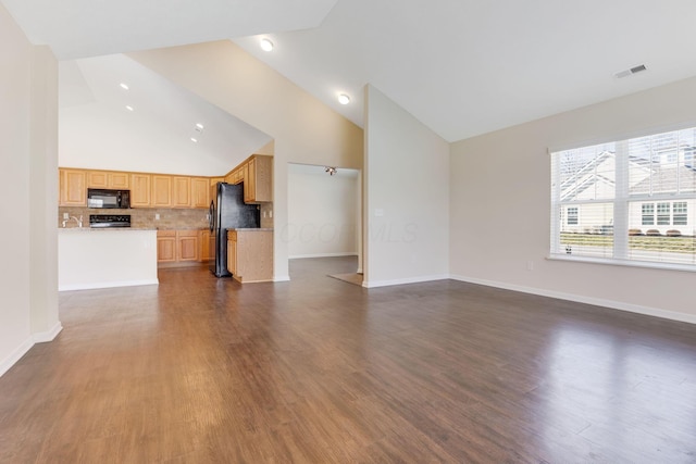 unfurnished living room with visible vents, dark wood-type flooring, and high vaulted ceiling