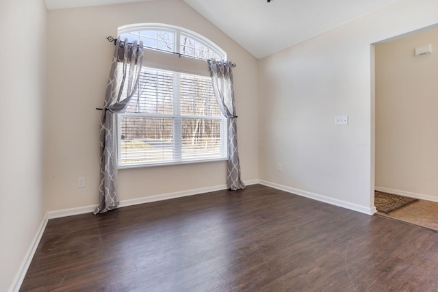 spare room with lofted ceiling, wood finished floors, and baseboards