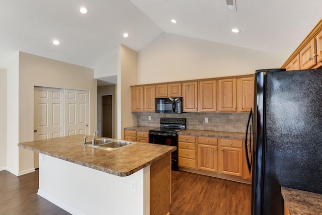 kitchen featuring dark wood-type flooring, black appliances, an island with sink, a sink, and backsplash