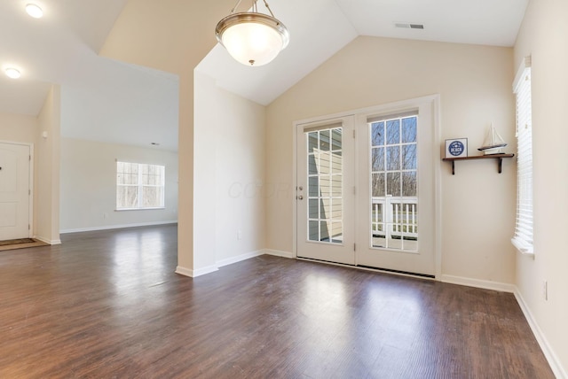 unfurnished room featuring lofted ceiling, baseboards, visible vents, and dark wood-type flooring