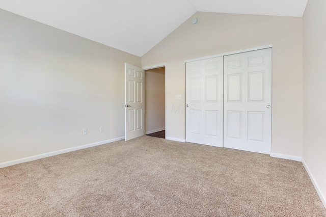 unfurnished bedroom with vaulted ceiling, carpet flooring, baseboards, and a closet