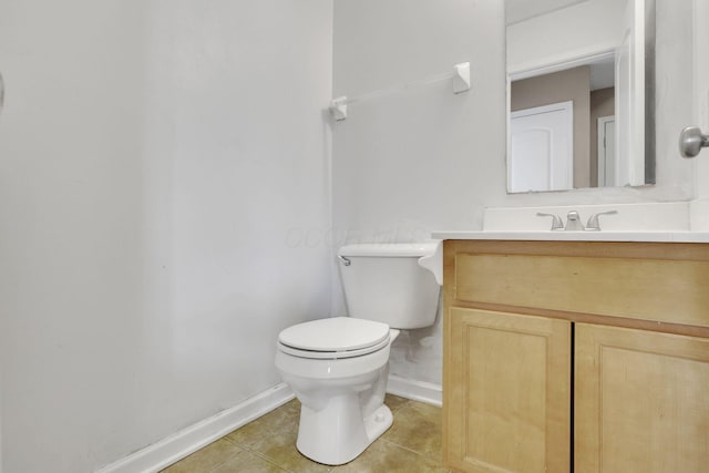 bathroom with baseboards, toilet, vanity, and tile patterned flooring