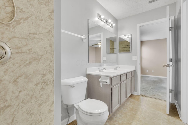 bathroom featuring tile patterned floors, toilet, a textured ceiling, baseboards, and vanity