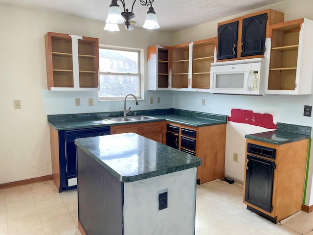 kitchen featuring open shelves, white microwave, dishwashing machine, and a sink