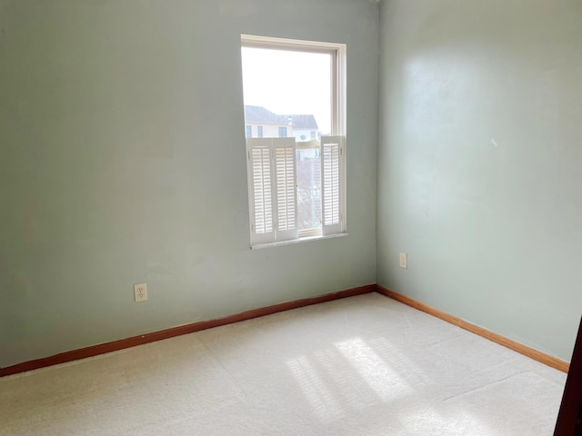 carpeted empty room with plenty of natural light and baseboards