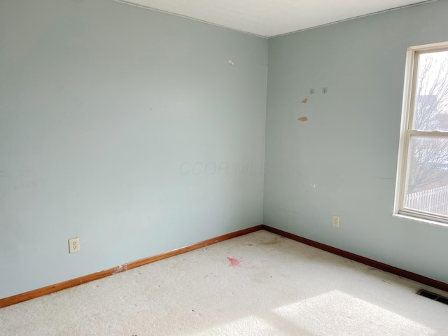 unfurnished room with carpet flooring, baseboards, and visible vents