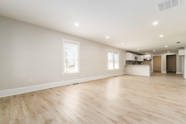 unfurnished living room featuring visible vents, recessed lighting, baseboards, and light wood-style floors