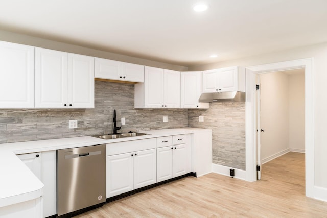 kitchen with under cabinet range hood, a sink, stainless steel dishwasher, white cabinetry, and light countertops