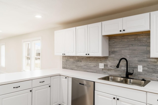 kitchen with a sink, white cabinetry, light countertops, and stainless steel dishwasher