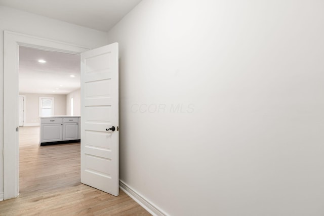 hallway with recessed lighting, baseboards, and light wood finished floors