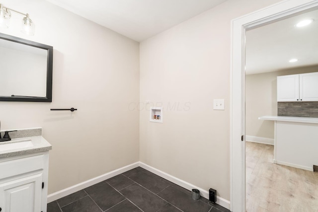 clothes washing area featuring a sink, recessed lighting, baseboards, hookup for a washing machine, and laundry area