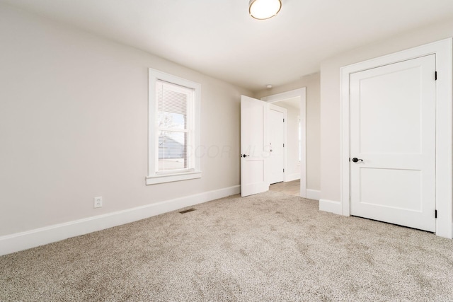 unfurnished bedroom featuring visible vents, carpet flooring, and baseboards