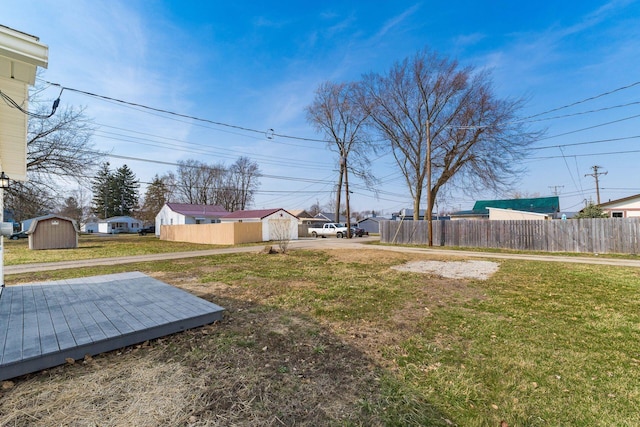 view of yard with fence, an outdoor structure, and a shed