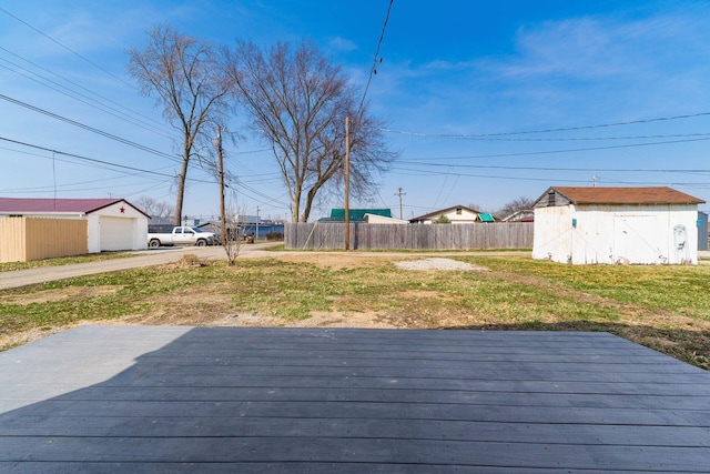 view of yard with a storage unit, an outbuilding, a garage, and fence