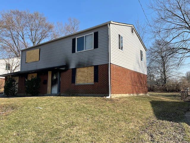 view of front of property featuring a front lawn and brick siding