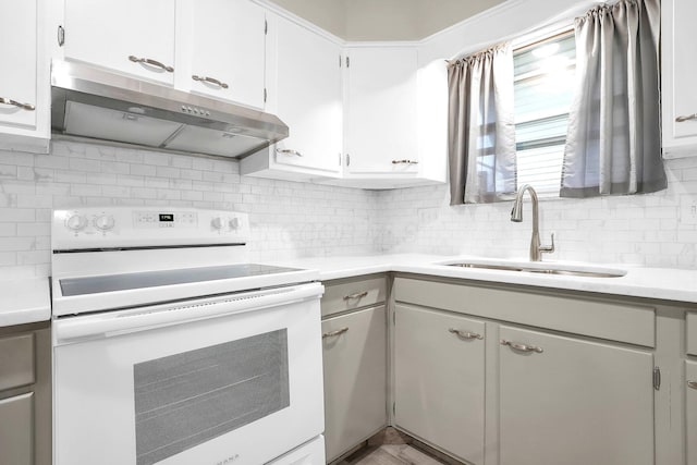 101 Cherokee Dr, Westerville, OH 43081 - kitchen featuring light countertops, under cabinet range hood, decorative backsplash, electric stove, and a sink