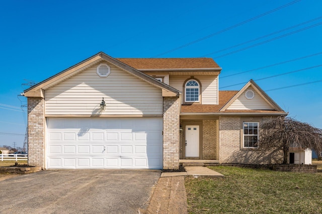 traditional home featuring brick siding, a shingled roof, a front lawn, aphalt driveway, and a garage