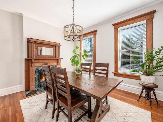 dining area featuring a fireplace, light wood-type flooring, and a wealth of natural light