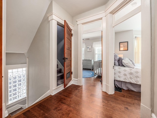 hall with baseboards, wood finished floors, and stairs