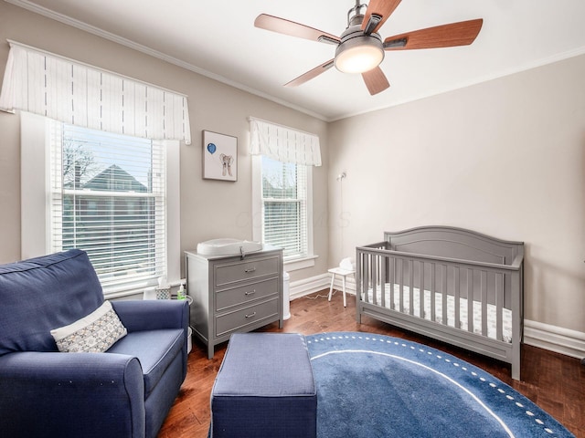 bedroom with baseboards, a ceiling fan, wood finished floors, and crown molding