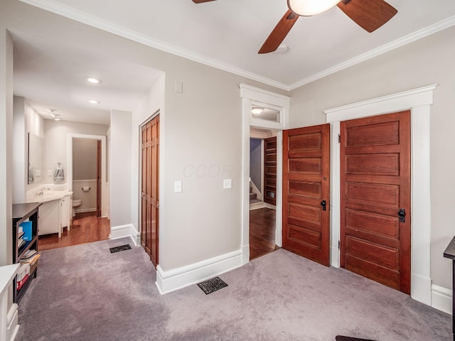 carpeted bedroom with visible vents, baseboards, and crown molding