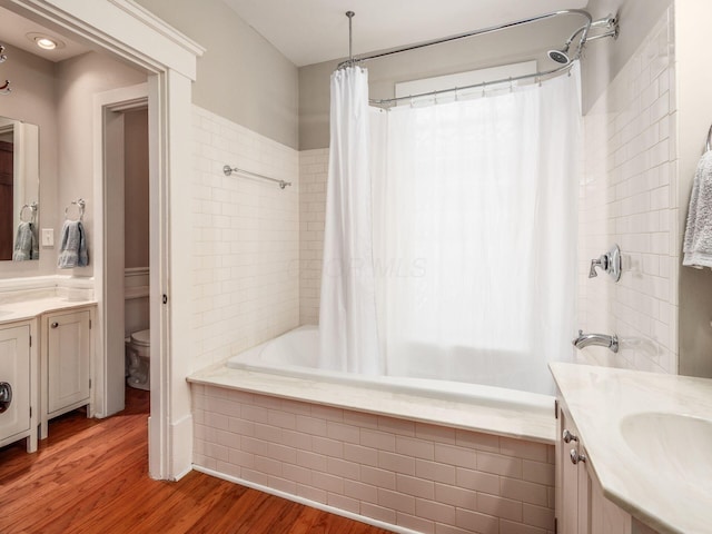 full bathroom with shower / tub combo with curtain, wood finished floors, vanity, and toilet