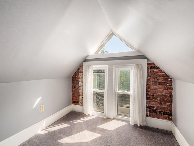 additional living space with baseboards, lofted ceiling, and carpet