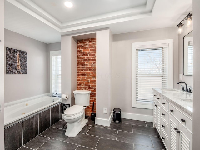 bathroom featuring a tray ceiling, toilet, a healthy amount of sunlight, and a whirlpool tub