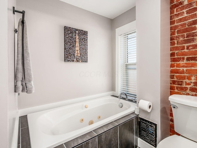 full bath featuring brick wall, toilet, and a whirlpool tub