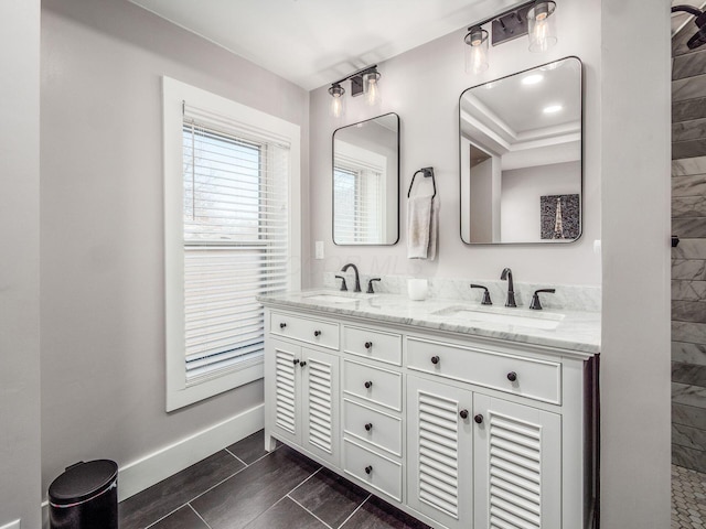 bathroom with a sink, baseboards, and double vanity