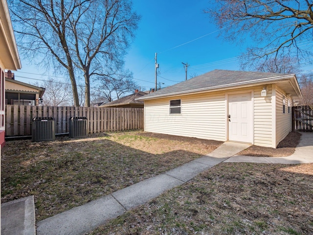 view of yard featuring central air condition unit, an outbuilding, and fence