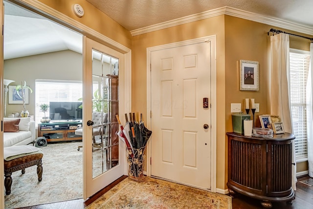 foyer entrance featuring a wealth of natural light, french doors, ornamental molding, and vaulted ceiling