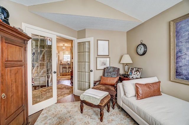 sitting room with vaulted ceiling, french doors, and wood finished floors