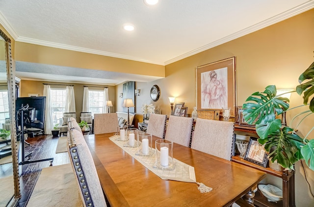 dining room featuring ornamental molding, a textured ceiling, and wood finished floors