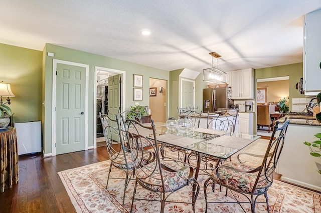 dining space featuring dark wood finished floors and baseboards