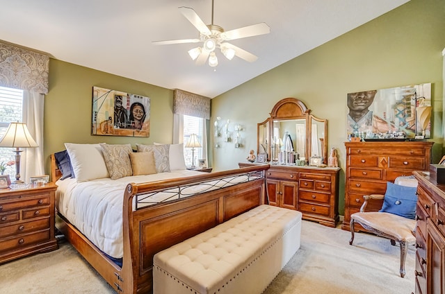 bedroom featuring multiple windows, light carpet, a ceiling fan, and vaulted ceiling