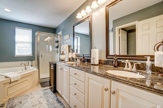 full bathroom featuring a sink, a bath, a stall shower, and tile patterned flooring