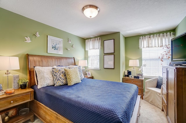 bedroom with light carpet and a textured ceiling