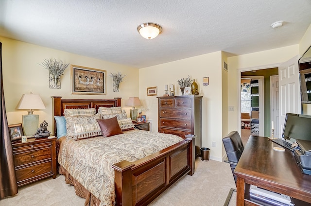 bedroom with light colored carpet and a textured ceiling