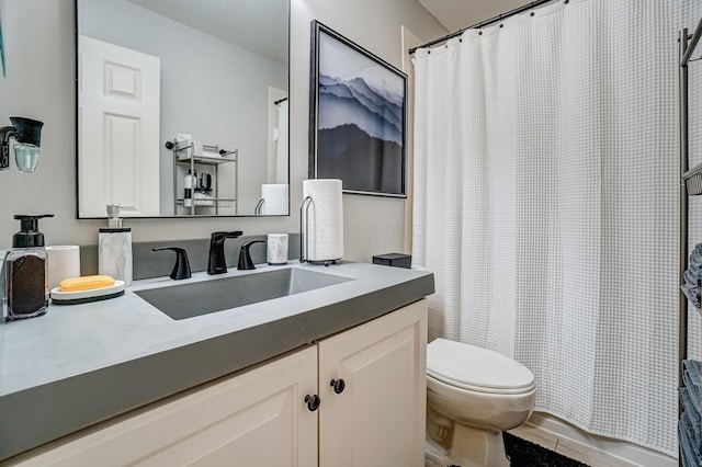 bathroom featuring toilet, vanity, and a shower with curtain